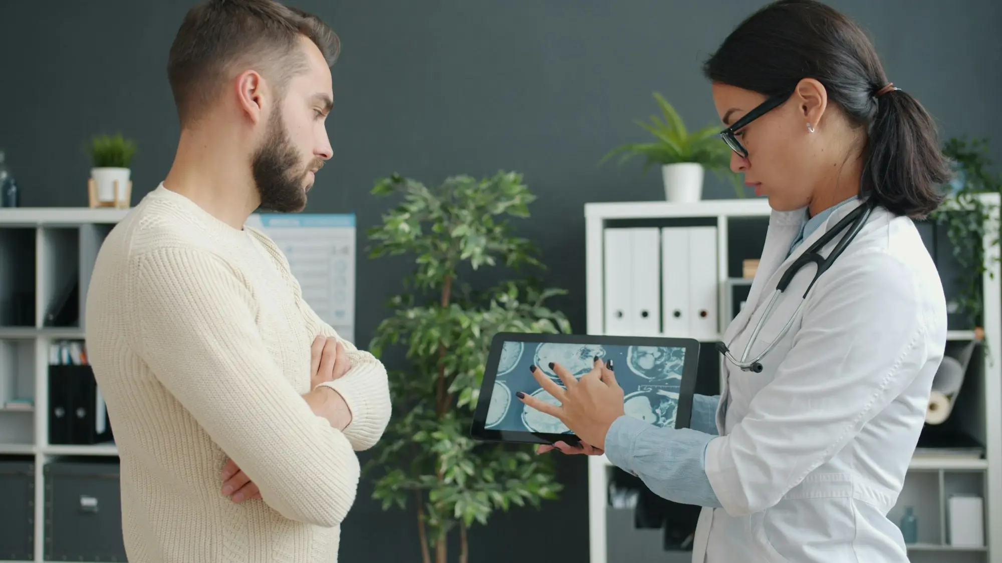Clinician showing a patient results on a tablet in a modern practice room