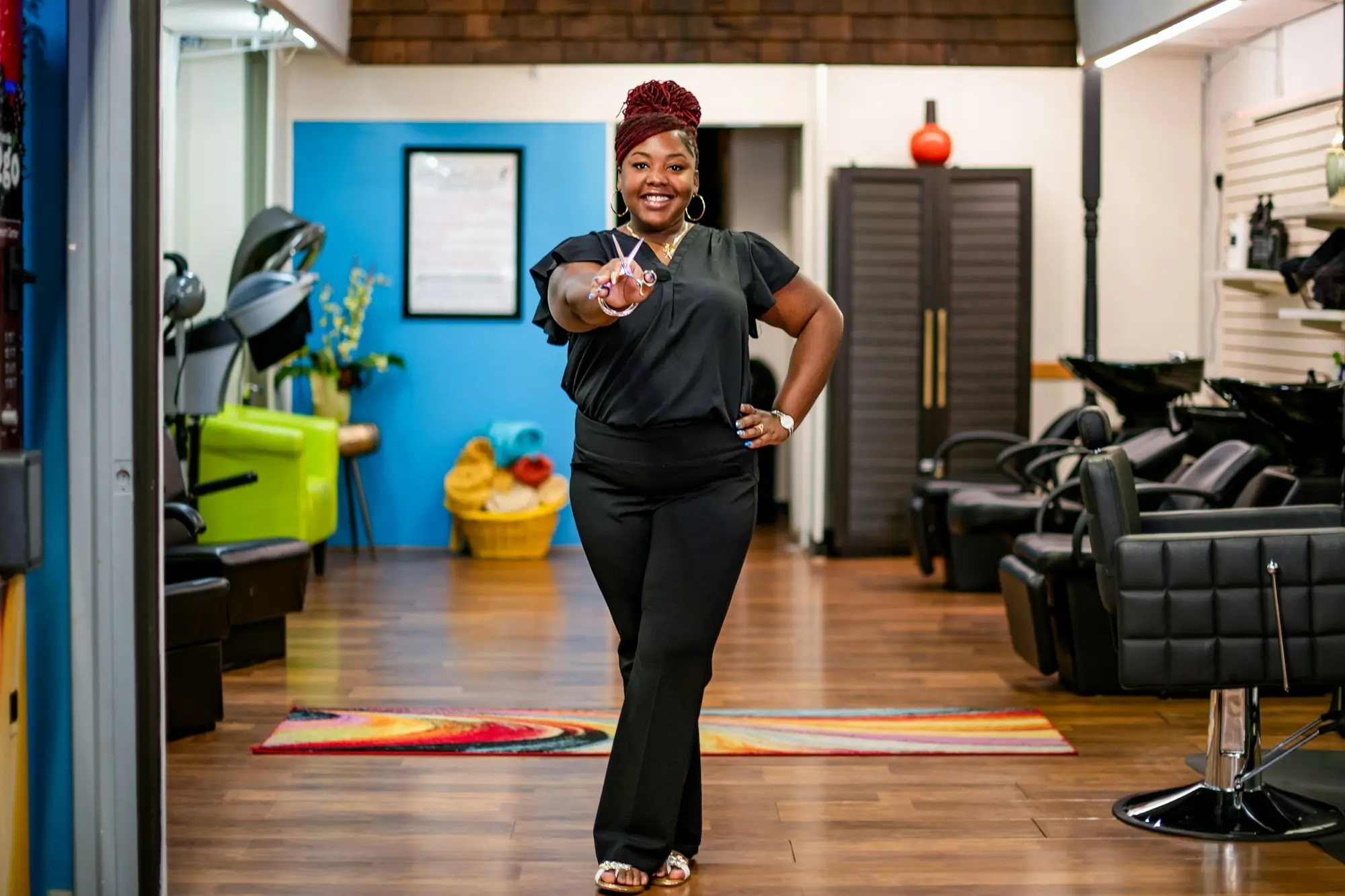 Salon owner smiling as she walks through her hair salon past styling chairs