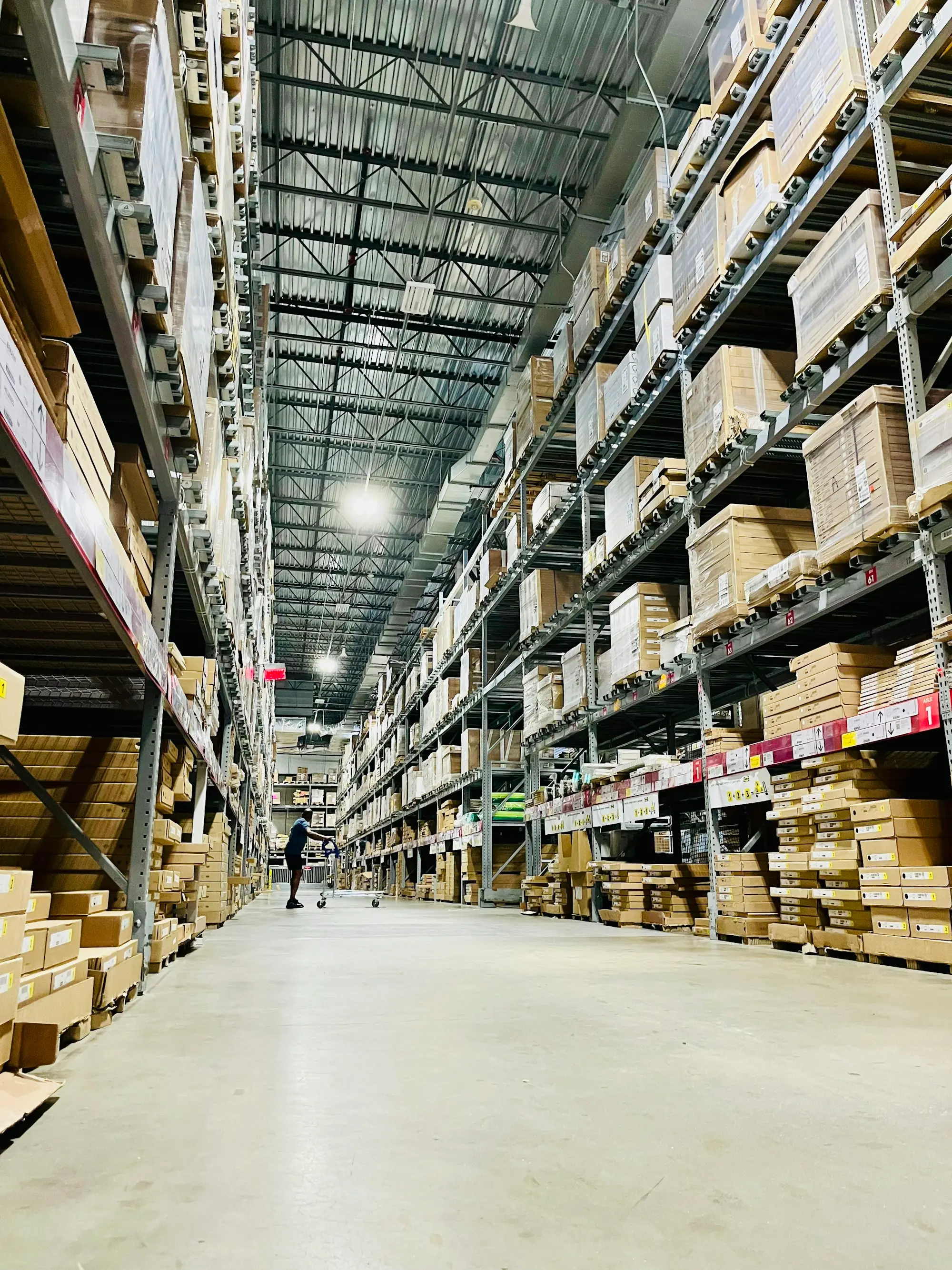 Long warehouse aisle with tall shelves stacked high with cartons of stock